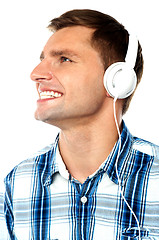 Image showing Young man tuned into music