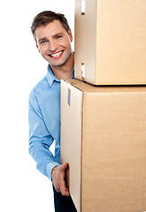 Image showing Smiling young man holding cardboard boxes