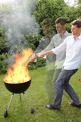 Image showing BBQ with fire an young man