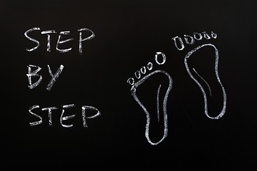 Image showing Footprints and the words step by step drawn with chalk