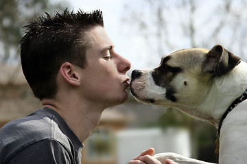 Image showing Boy kissing his dog