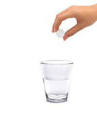 Image showing Tablet of sedative in a hand above a glass with water