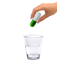 Image showing Hand and big pill with glass water - concept