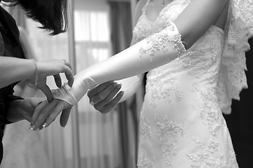 Image showing Friend help the bride to wear a glove.