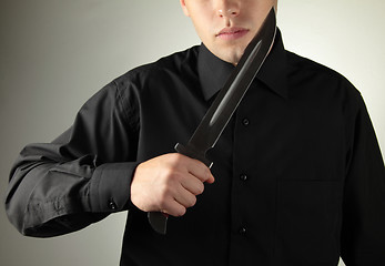 Image showing standing man in black with knife