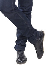 Image showing Man's feet in blue trousers and black shoes