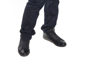 Image showing Man's feet in blue trousers and black shoes