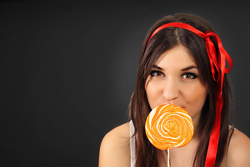 Image showing pretty happy curly girl with a lollipop in her hand