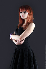 Image showing girl with red hair poses on black background