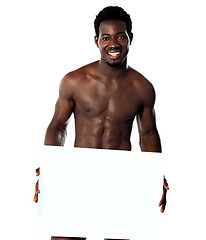 Image showing Young muscular man holding blank billboard