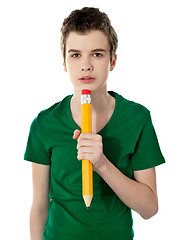 Image showing School boy thinking while holding pencil