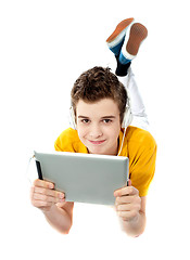 Image showing Boy lying on a floor with wireless device