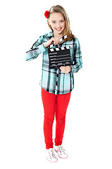 Image showing Smiling girl holding clapperboard
