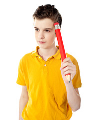 Image showing Thoughtful boy holding a pencil