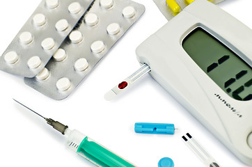 Image showing Glucometer with pills and a syringe