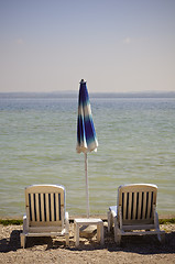 Image showing Beach chairs and closed umbrella on the beach