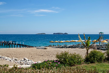 Image showing beach with pier and umbrellas