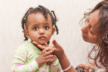 Image showing A mother caressing her baby girl