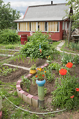 Image showing Various old items adorn the garden at the cottage