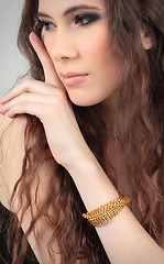 Image showing cute girl touching her face with bracelet on her arm