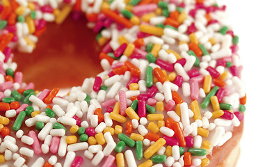 Image showing Pink Iced Doughnut covered in sprinkles isolated