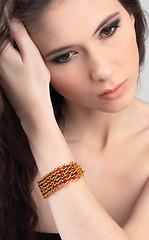 Image showing beautiful girl straightens her hair with bracelet on her arm