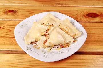 Image showing Cooked raviolli with mushrooms on a shiny white plate