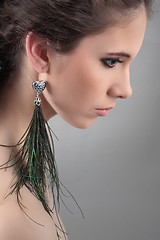 Image showing profil of a beautiful girls with green earrings 