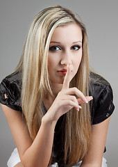 Image showing very attractive female holds finger on her lips