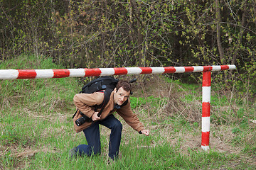 Image showing A young man passes under the barrier