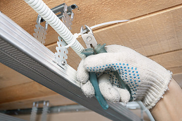 Image showing The builder lays the electrical wiring