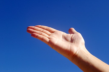 Image showing Giving hand under blue sky