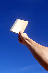 Image showing Holding notebook under blue sky