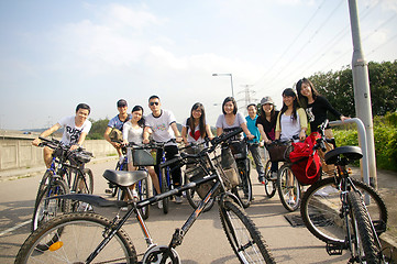 Image showing Asian friends riding bicycle