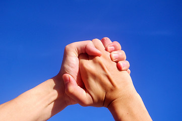 Image showing Holding hands under blue sky