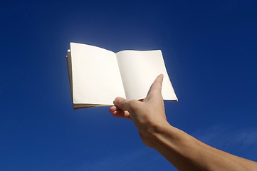 Image showing Holding notebook under blue sky