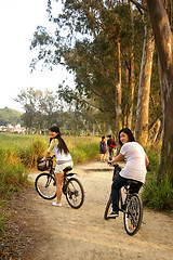 Image showing Asian friends riding bicycle