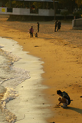 Image showing Children playing on beach under sunset