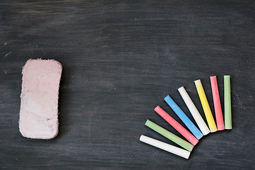 Image showing Colorful chalk and eraser on a blank smudged blackboard