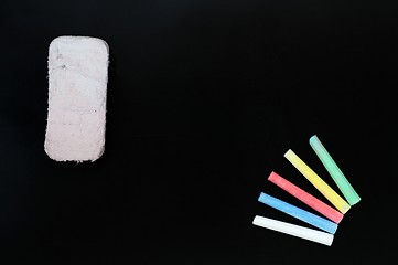 Image showing Colorful chalk and eraser on a blank blackboard