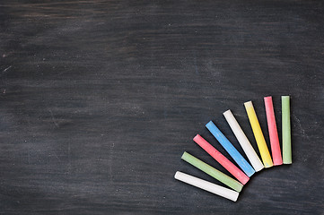 Image showing Colorful chalk on a blank smudged blackboard