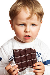 Image showing The little boy eats chocolate