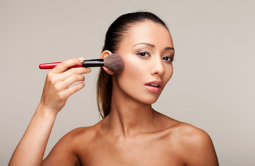 Image showing Young beautiful woman applying makeup