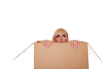Image showing Scared young blonde emerging from a box