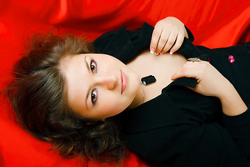 Image showing attractive brunette in black on red