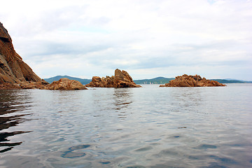 Image showing Rocks in the blue sea, illuminated by the sun. Background.