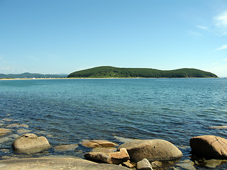 Image showing Rocks in the blue sea, illuminated by the sun. Background.