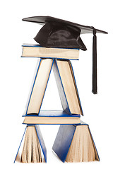 Image showing books with black cap of bachelor isolated on white