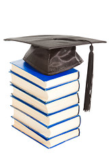 Image showing books with black cap of bachelor isolated on white