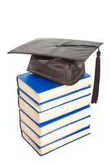 Image showing books with black cap of bachelor isolated on white